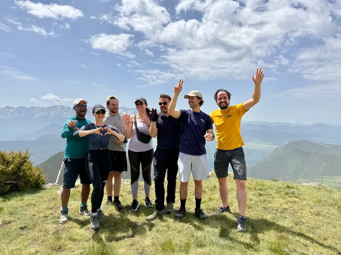 The Acai Travel team on a hillside above the mountains